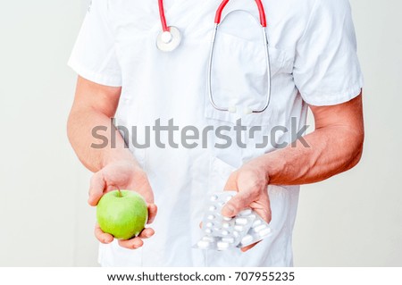 doctor  in white uniform, with red stethoscope, offering medications and medicines or fruits
