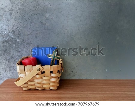 Wooden basket of Christ cross, bible, candle, on grunge vintage background