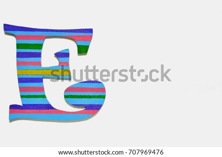 Single sawn wooden letter E symbol coated with paint on a white background, copy space