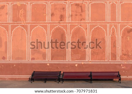 Horizontal picture of benchs with painted wall inside of City Palace in Jaipur, known as pink city of Rajasthan in India.