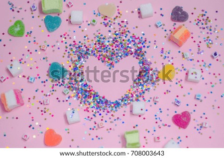 Heart-shaped frame and colorful candy for background.