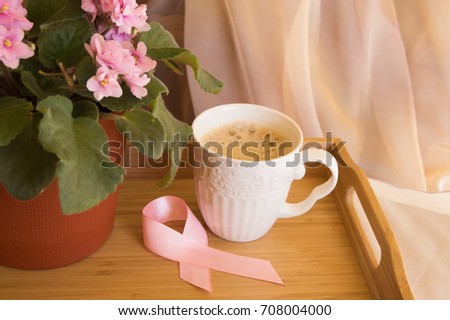 Breakfast for women - pink ribbon awareness symbol breast cancer. Coffee Cup on a wooden tray and pink violet. Royalty-Free Stock Photo #708004000