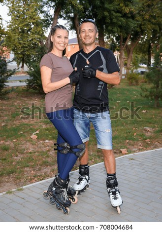 a guy and a girl on roller skates in the Park, a clear summer day