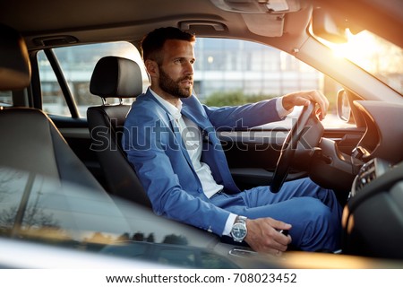 Attractive elegant man in business suit driving car
 Royalty-Free Stock Photo #708023452