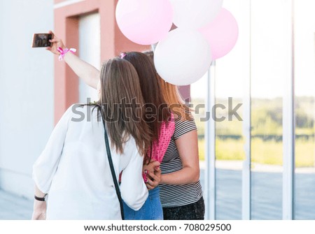Three happy best girlfriends making selfie on smartphone. Women's party before the wedding. Girls with pink and white balloons. Birthday party. 