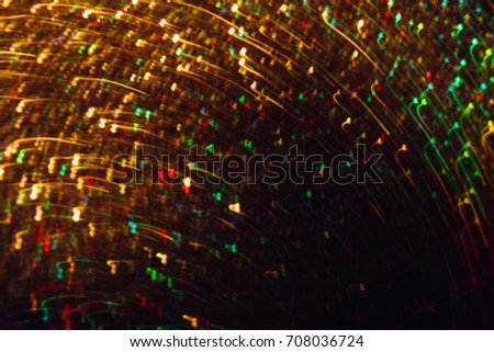 Abstract picture of colorful blurred glitters in motion. Golden, red and green holiday bokeh background with copy space. Defocused lights backdrop, Christmas and New Year wallpaper decorations concept