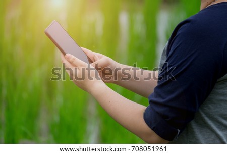 people holding smartphone with nature background. 