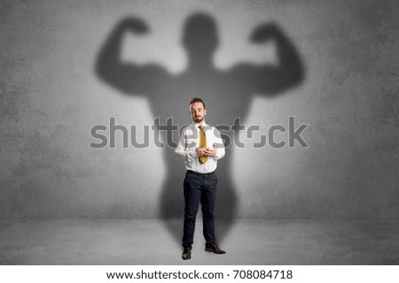Lovely serious businessman standing with a muscular powerful shadow behind his back
