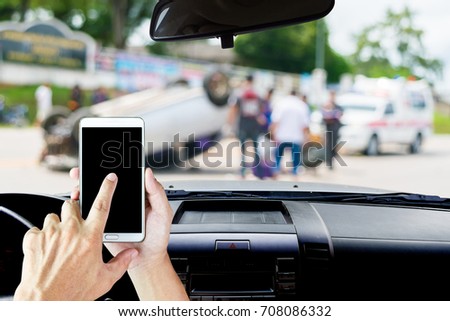 Man use mobile phone in the car, blur image of car accident scene upside down on the road as background.