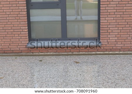 somebodys legs reflected in a modern building window in groundfloor