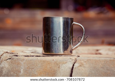 Metal cup. Outdoor. Toned photo.
