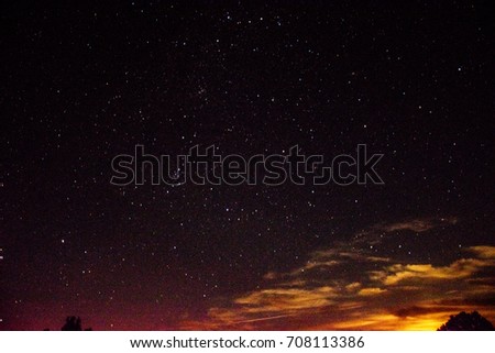 Night sky landscape. Night stars and clouds over the forest. Long exposure photography
