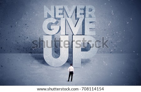 A stressed out business worker standing in front of huge block letters saying never give up in blue open environment concept
