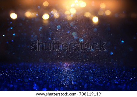 glitter vintage lights background. blue, gold and black. de focused.