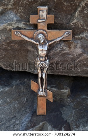 Silhouette of the crucified Jesus Christ on the cross the background of granite stones. The biblical prophet is the symbol of death. Mountain Calvary, Christmas, Easter background.