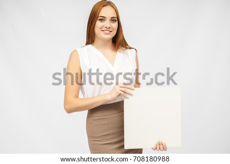 Young woman holding blank poster.Smiling woman sign board holding. Girl showing banner with copy space.