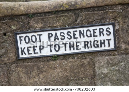 Foot Passengers Keep Right sign on an old stone wall background
