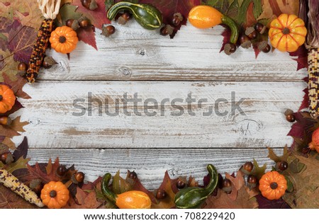 Autumn foliage with gourds, corns and acorns for Thanksgiving and fall holidays. Complete circle border background with plenty of copy space in middle