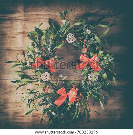 Christmas wreath with mistletoe on wood desk. Christmas decoration.