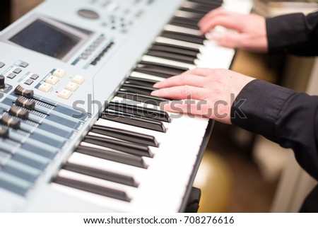 Male hands playing on the electronic piano