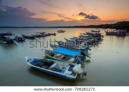 Fishermen boats and old jetty grounded during sunset. East coast of Malaysia.This image may contain noise ,blurry clouds due to long exposure, soft focus and poor lighting