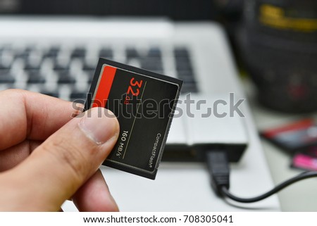 Hand holding 32GB compact flash memory card 