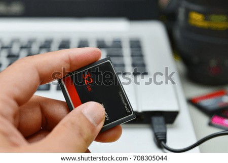 Hand holding 32GB compact flash memory card 