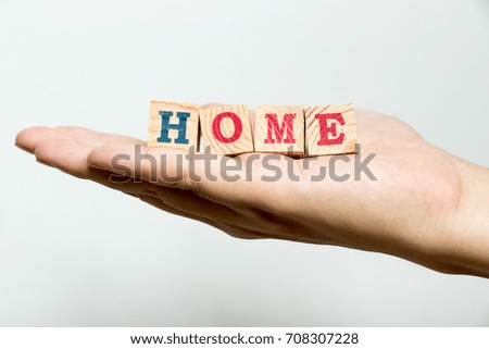Man hold wood block with wording home on concrete background
