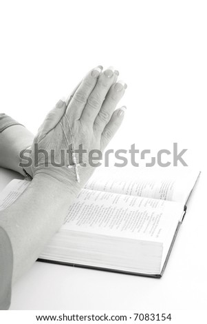 praying hands over bible black & white