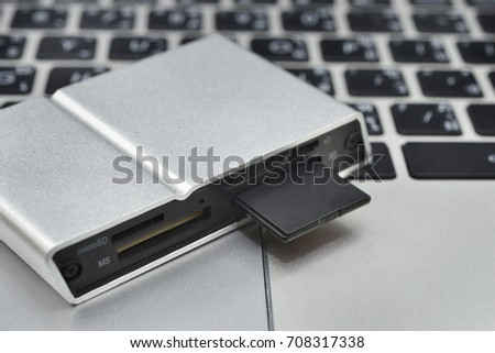 SD card in card reader on keyboard notebook background