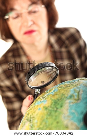 senior teacher holding magnifier and looking the world map selective focus image