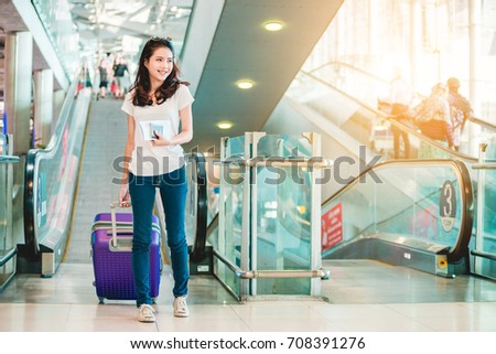 Asian women were carrying luggage around the international airport. She was traveling abroad to travel on weekends. Royalty-Free Stock Photo #708391276