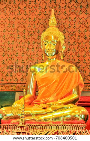 Golden Buddha Image dressed with robes in Buddhist church