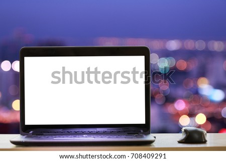 Laptop top on wooden table on purple bokeh background. Blank white screen notebook for display free space montage.