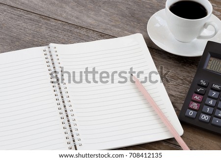 notebook with coffee cup and calculator on wooden table. with copy space for text.