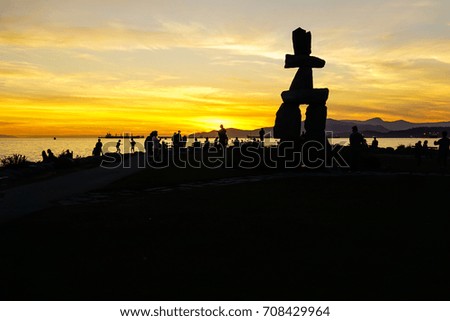 The silhouette of Olympic Statue and the crowds at the moment of the beautiful sunset at English Bay, Vancouver, British Columbia.
