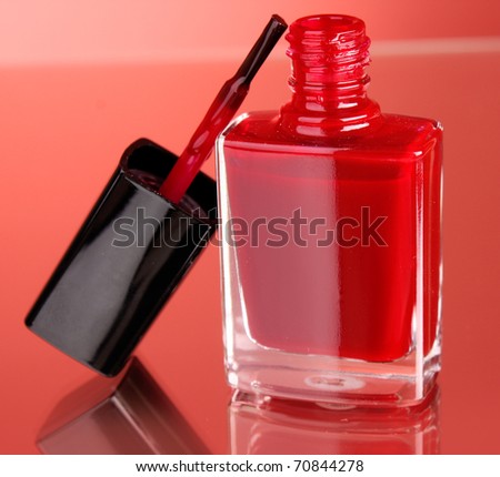 Pink nail polish on red background