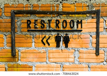 Restroom sign on the brick wall
