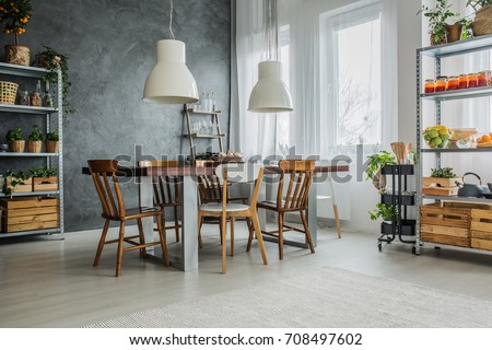 Cozy loft with dinning table, chairs and metal storage racks Royalty-Free Stock Photo #708497602