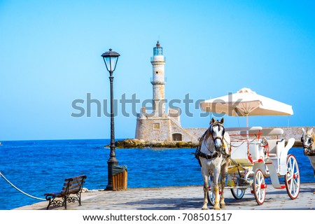 The old harbor of Chania with horse carriages and lighthouse, Crete, Greece. Royalty-Free Stock Photo #708501517