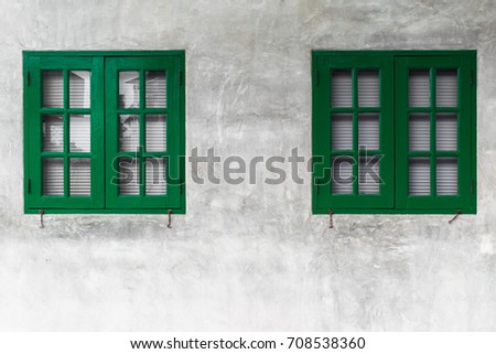 Close wooden shutters on cement background.Green window on a concrete wall,Lime Green Window.Green wooden door and shutters close.