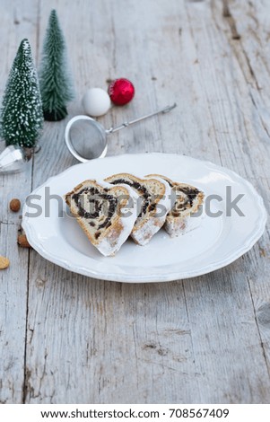 Poppy seed stollen on beautiful plate on wooden table. Natural light, selective focus.
