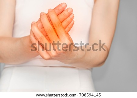 woman with finger pain or hand.Acute pain in a woman hand. Concept photo with read spot indicating location of the pain.