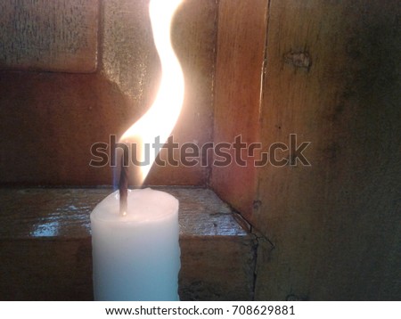 White candle with dancing fire.