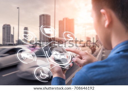 The abstract image of business man point to the hologram on his smartphone and blurred traffic is backdrop. the concept of communication, network, insurance, financial and internet of things.