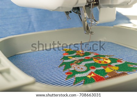 Picture Close up of embroidery machine stop working after embroidered christmas tree on cotton fabric