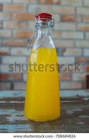 Fresh  orance juice inside the bottle on wall loft style background.