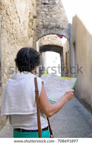 an happy female tourist searching road on map in city during vacation