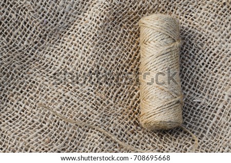 Skein jute twine and burlap on a wooden background. Rustic style. Selective focus.