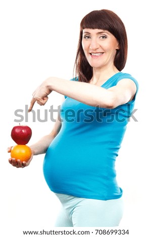 Happy pregnant woman showing fresh fruits, concept of healthy food and nutrition during pregnancy, expecting for newborn